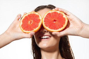 Summer. Close up of beautiful young woman with big grapefruit on white background. Concept of cosmetics, makeup, natural and eco treatment, skin care. Shiny and healthy skin, fashion, healthcare.