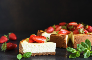 Slice of cheesecake with strawberries and mint on a dark background. Cheesecake New York. Advertising. Restaurant menu.