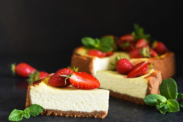 Slice of cheesecake with strawberries and mint on a dark background. Cheesecake New York. Advertising. Restaurant menu.