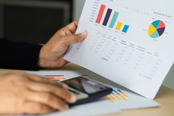 Asian accountant working and analyzing financial reports project accounting with chart graph and...