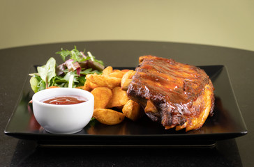 Baked pork ribs with barbecue or BBQ sauce and wedges