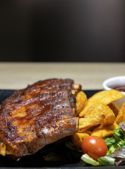 Baked pork ribs with barbecue or BBQ sauce and wedges