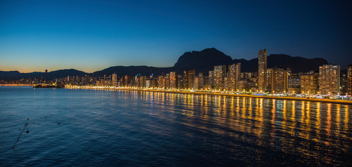 Fototapeta premium Night city by the sea with an empty beach and beautiful night lighting, Summer background