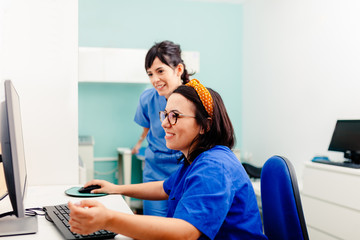 Two nurses using a computer in a x-ray room