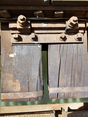A rusted railroad bridge on a sunny day with cloudy blue sky on the background.