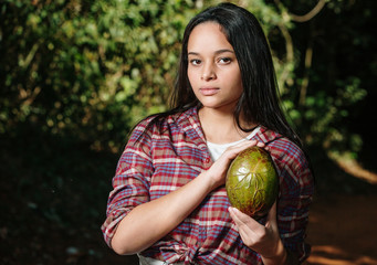 Young girl holding avocado in a shape similar to a heart. Avocado is a low fat food.