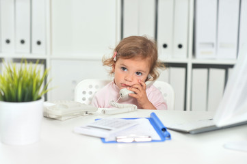 Cute little girl using phone in office