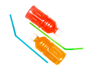 two plastic bottles with juice from orange and grapefruit on a white background