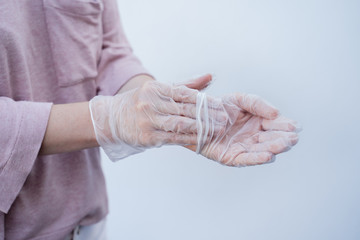 close-up of a woman's hands removing disposable safety gloves during the coronavirus pandemic