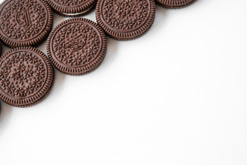 Several chocolate cookies with milk filling are isolated on a white background. Left an empty space on the right