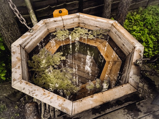 Outdoor wooden bath with fir therapy. Coniferous branches in bath Hot water. Healtly procedures 