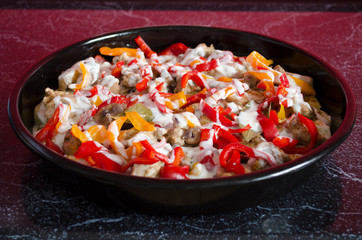 Meat casserole with vegetables and sauce close-up. Cooking process. Homemade stew in the pan for oven.
