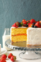 Composition with delicious berry cream cake on white wooden table. Tasty dessert