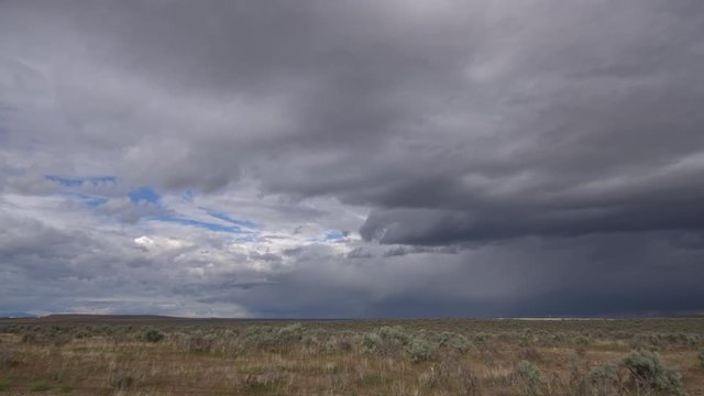 Time lapse of storm clouds clearing out in the Idaho landscape as they move over the horizon.