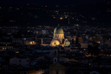 Vista de ciudad con iglesia en centro a la noche