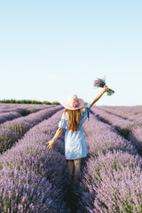 Girl with a hat on her head in the lavender field