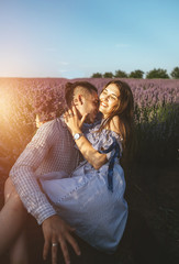 Beautiful young couple embracing and walking together outdoor in lavender field.