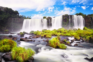 Iguazu waterfalls in Argentina, view from Devil's Mouth. Panoramic view of many majestic powerful water cascades with mist. Long exposure, long water. Panorama of Iguazu valley from high up..