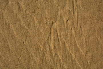 Golden sand on the beach close-up texture for background or wallpaper