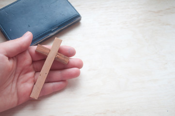 Hand holds wooden cross, easter day, world prayer day, international prayer day	