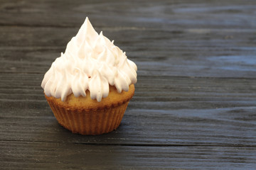 muffins with airy pink cream on a wooden black background