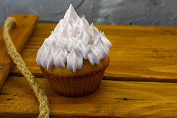 muffins with airy pink cream on a wooden black background