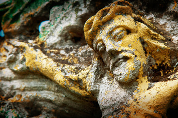 Close up fragment of very old and ancient statue: the suffering of Jesus Christ