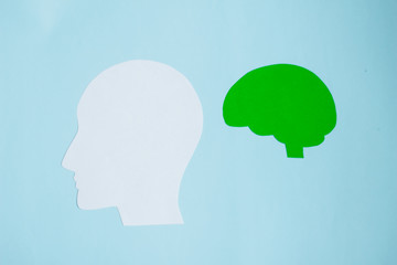 Green human brain with white face on blue background,  Memory loss, dementia, Alzheimer's disease and mental health concept. paper cut.