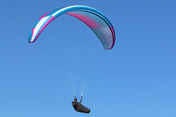 Paraglider flying wing in a blue sky	