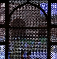 people behind lattice craft window mosque