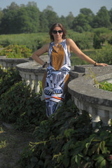 woman in the summer in the park in sunglasses and summer overalls