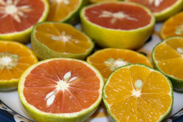 Beautiful lemons, bergamots and grapefruits cut in half on a cutting board.