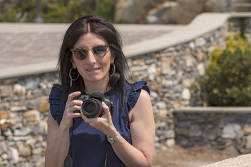 Young photographer and his SLR look into the camera