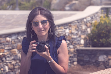 Young photographer and his SLR look into the camera