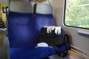 an office bag in a train compartment, with plastic gloves and a face mask, N95 mask, after coronavirus COVID -19, a regular equipment outfit of a commuter public transport 