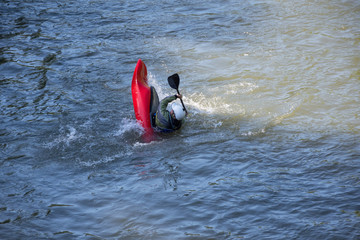 Man in capsizing kayak; kayak skills training in high-water river; Struma River, Kresna Gorge, Bulgaria