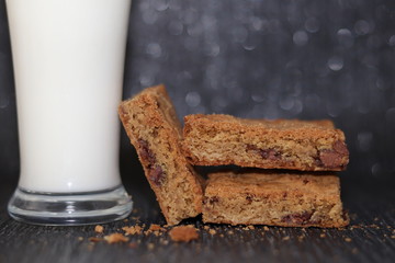 Close up of chocolate cookie bars and a glass of milk