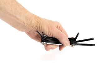 a male hand holding a folding set of hex keys ready to tghten a screw isolated on white