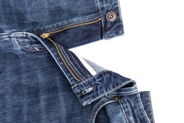 The open zipper of blue denim jeans open on a white background