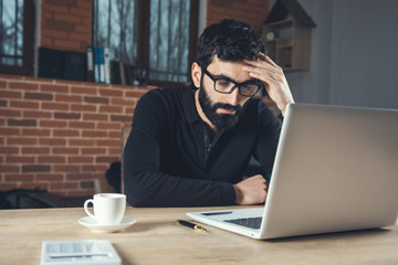 sad man working in computer in office