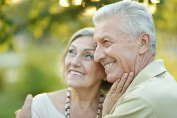 Smiling senior couple embracing in autumn park