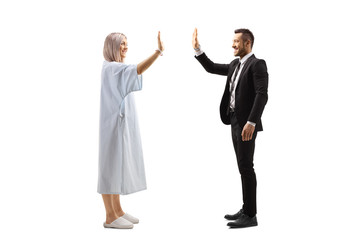 Female patient gesturing high-five with a businessman