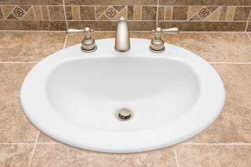 White drop in sink on tiled counter