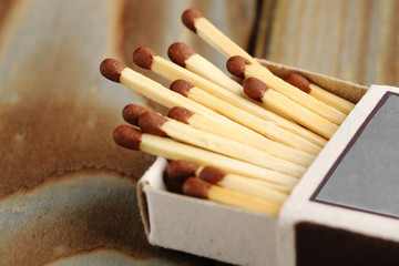 Open box with matches lies on a wooden table, closeup.