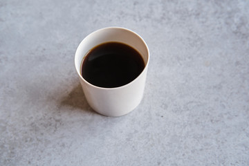 Cup of black coffee in a handmade white ceramics mug, white marble background