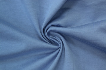 Fototapeta premium Light blue background of fabric from a piece of crumpled clothes. Top view. crumpled polyester. The texture of the fabric, useful as a backdrop.