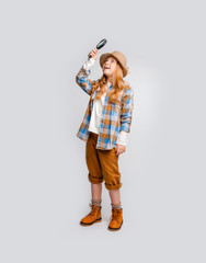 cute long-haired emotional girl in clothes traveler explores something, looking through a magnifier