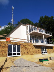 Neubau von Ferienwohnungen mit großen Balkons vor blauen Himmel im Sonnenschein am Südhang des...