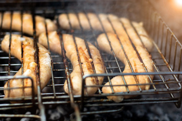 sausages lie on the grill and grilled at the stake. picnic in nature. bright highlight. close-up
