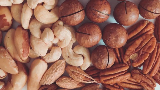 Top view of macadamia, cashews and brazil nuts on a gray background, close, flat lay